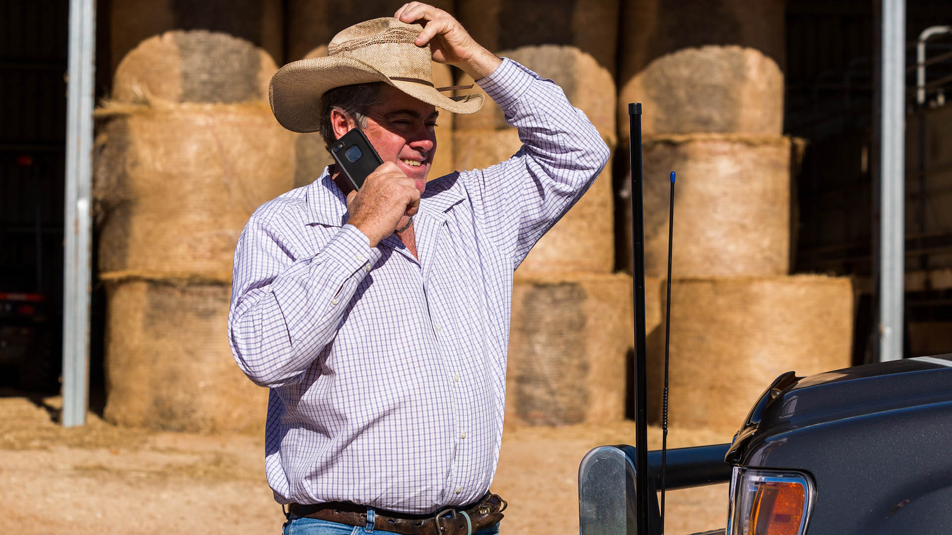 Farmer in hat holding a cell phone